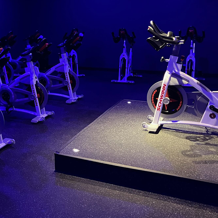 The dedicated cycling studio with rows of spin bikes and accent lighting